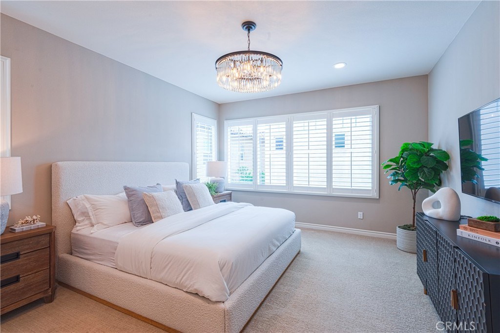 120 Mongoose Irvine, CA 92618 - Photo 7 of 42 a spacious bedroom with a bed and a chandelier
