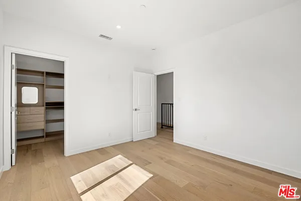 a kitchen with white cabinets and a wooden floor