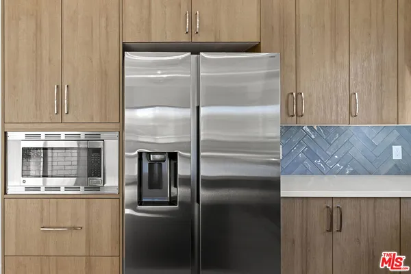 a kitchen with kitchen island a counter top space cabinets and stainless steel appliances