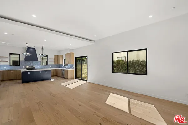 a large white kitchen with stainless steel appliances kitchen island a large counter top a stove and a sink