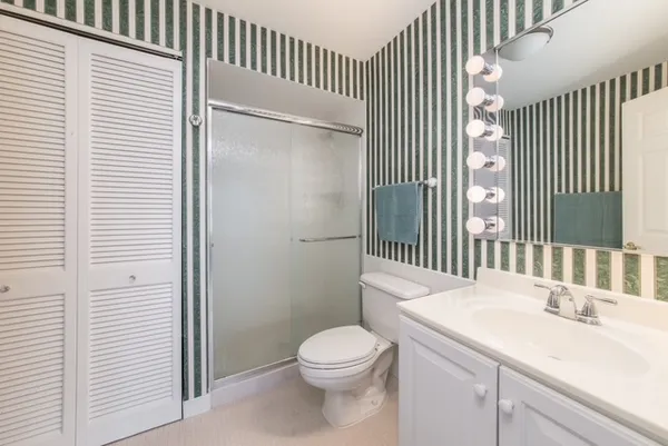 a bathroom with a sink a toilet and shower