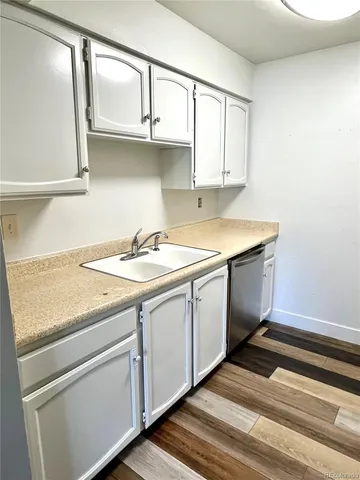 a kitchen with granite countertop white cabinets and white appliances