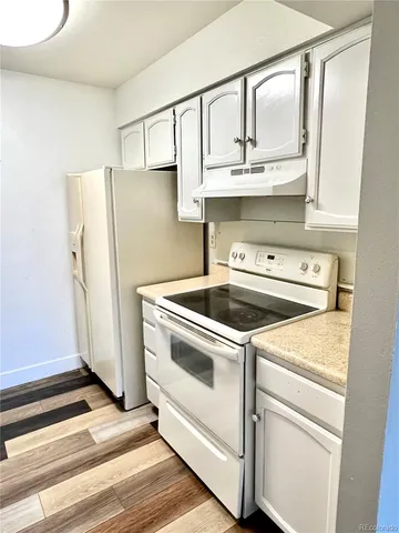 a kitchen with white cabinets and white appliances