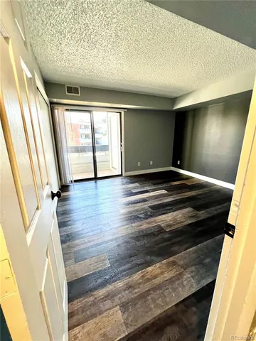 a view of an empty room and wooden floor