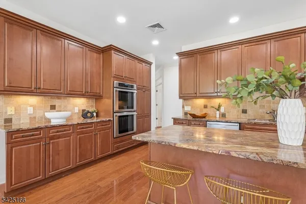 a kitchen with stainless steel appliances granite countertop a stove a sink and a microwave