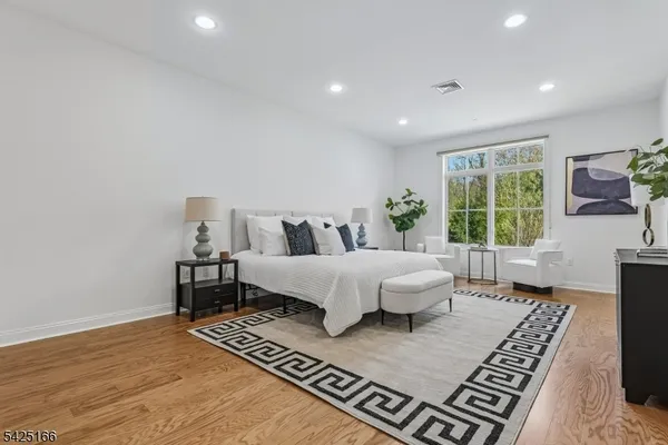 a bed sitting in a spacious bedroom next to a window