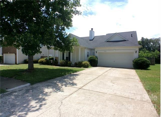 a front view of a house with a yard and trees