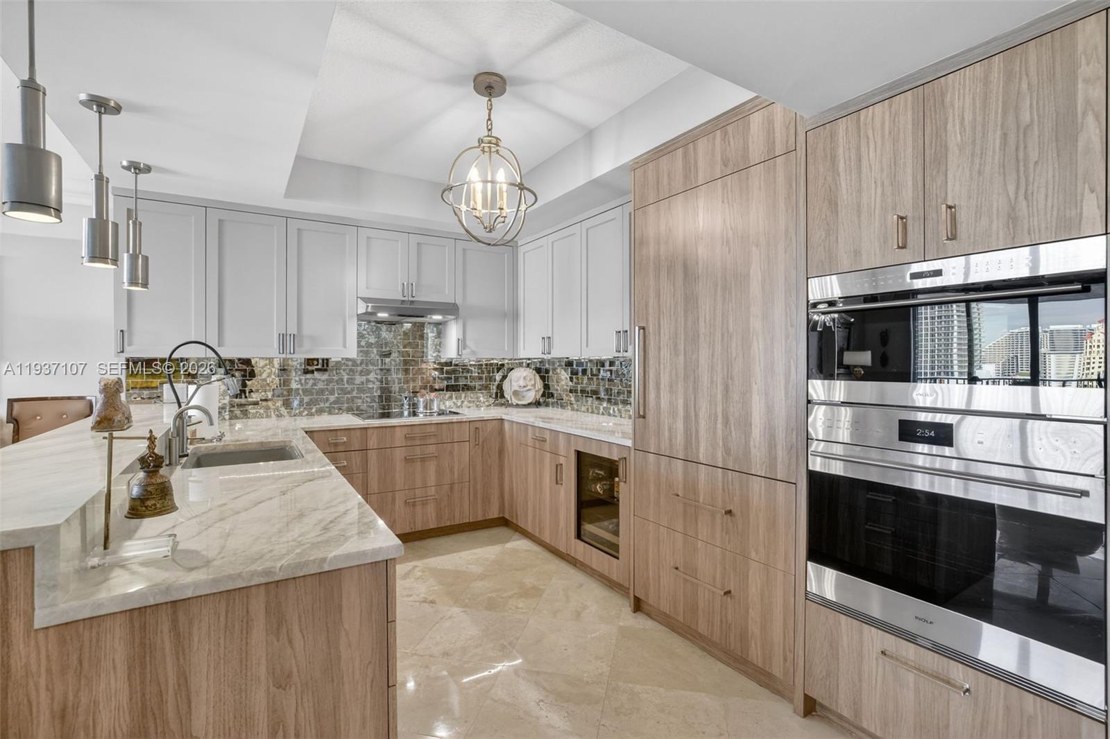 100 South Birch Road, Unit 1103F Fort Lauderdale, FL 33316 - Photo 31 of 80 Spectacular kitchen w/ custom bleached walnut veneer cabinetry by renowned Chicago based millworker. Grain matches from top to bottom. Taj mahal quartzite. Wolf induction cooktop & double oven (w/ microwave / convenction at top oven), Sub Zero Refrigerator & Beverage Cooler, Miele Dishwasher. Sink w/ touchless Brizo faucet, including water filtration faucet. Antiqued mirror backsplash