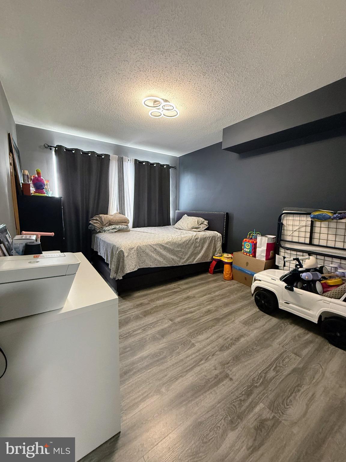 5831 Quantrell Avenue, Unit 505 Alexandria, VA 22312 - Photo 13 of 22 a living room with two bed furniture and a flat screen tv
