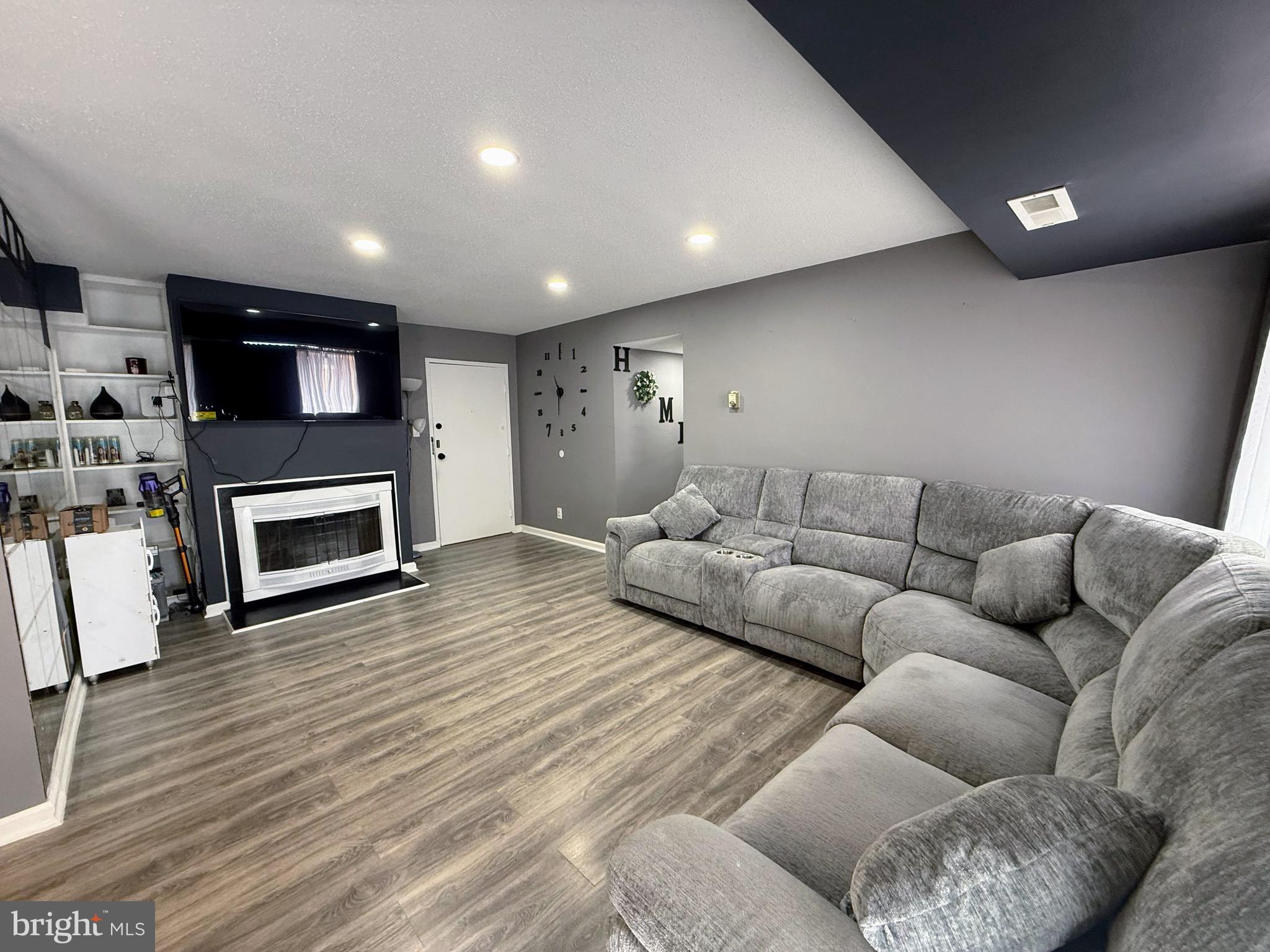 5831 Quantrell Avenue, Unit 505 Alexandria, VA 22312 - Photo 3 of 22 a living room with furniture a fireplace and a wooden floor