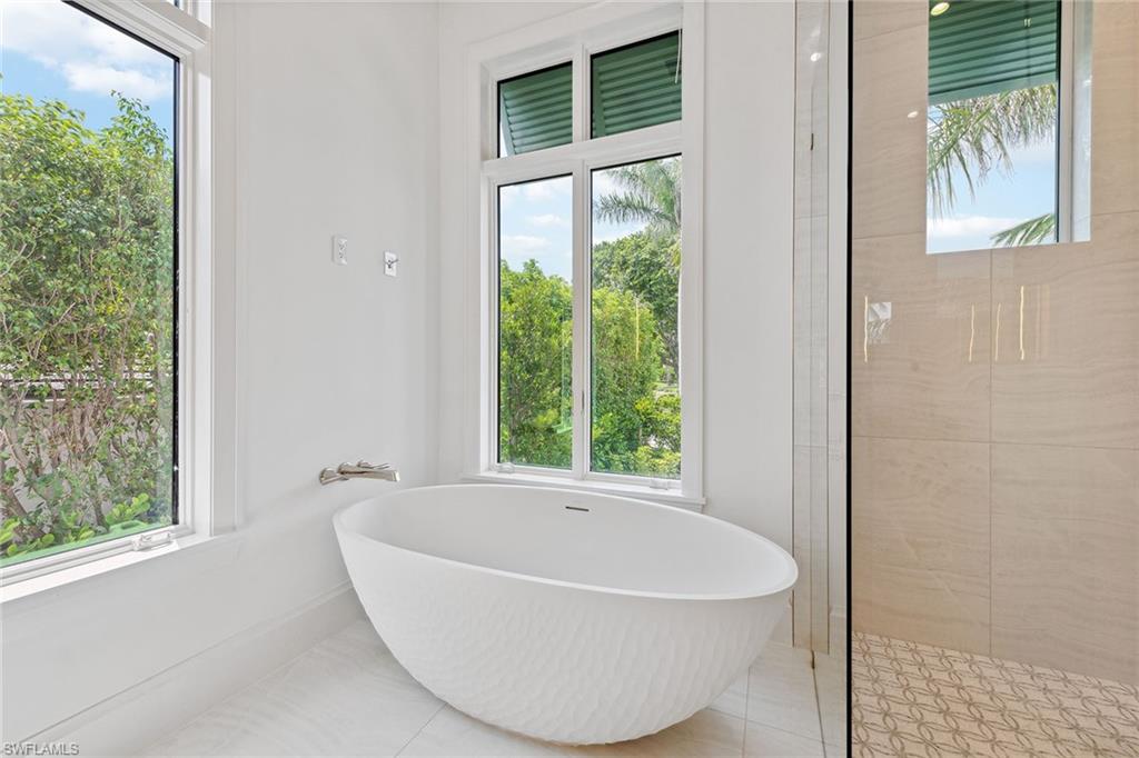 3636 Crayton Road Naples, FL 34103 - Photo 14 of 19 a white bath tub sitting in a bathroom next to a window