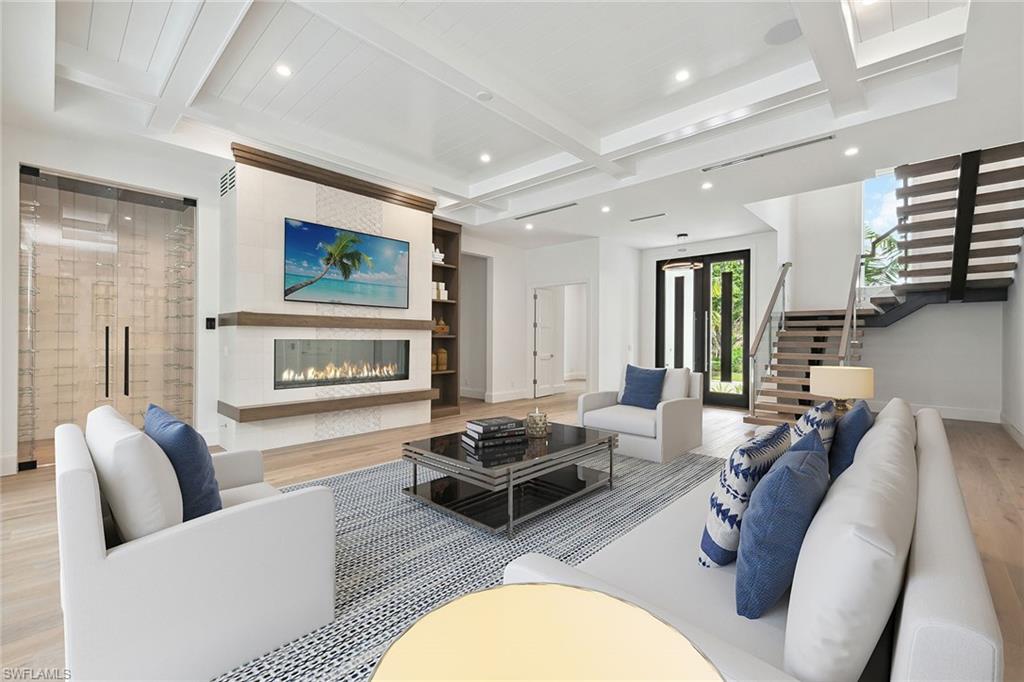 3636 Crayton Road Naples, FL 34103 - Photo 4 of 19 a living room with furniture a flat screen tv and a fireplace