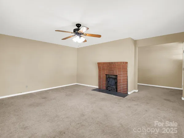 an empty room with windows and fireplace