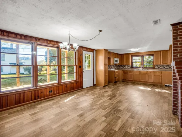 a view of a livingroom with a furniture chandelier and wooden floor