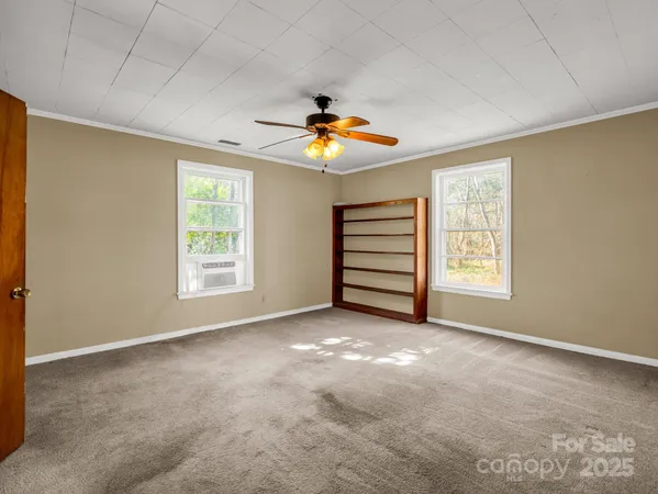 an empty room with closet and a chandelier fan