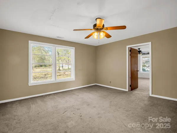 a view of a room with a ceiling fan and a window