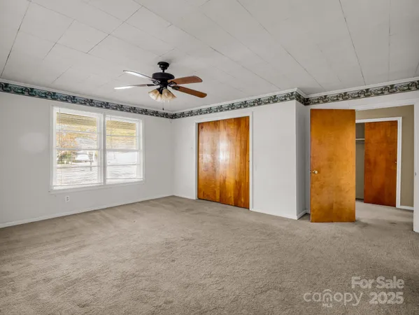 a view of empty room with a ceiling fan and window