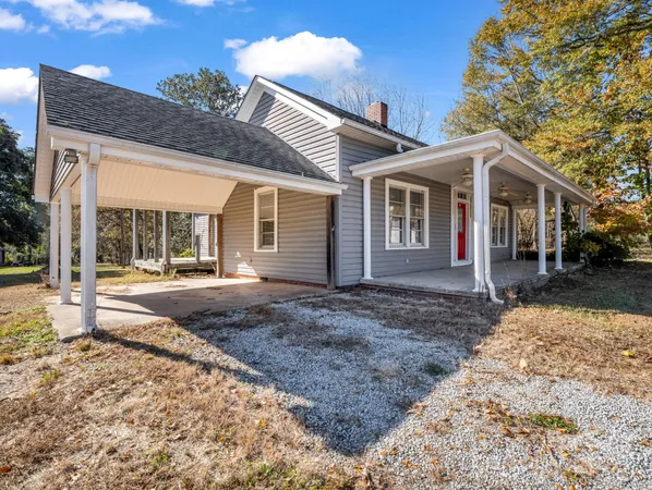 a view of a house with a yard and pathway