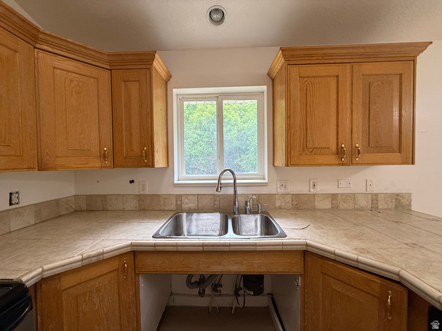 838 East Mountain Road Logan, UT 84321 - Photo 12 of 37 Kitchen featuring a double stainless steel sink, wood cabinetry, light-toned tile countertops, a matching tile backsplash, and a window above the sink