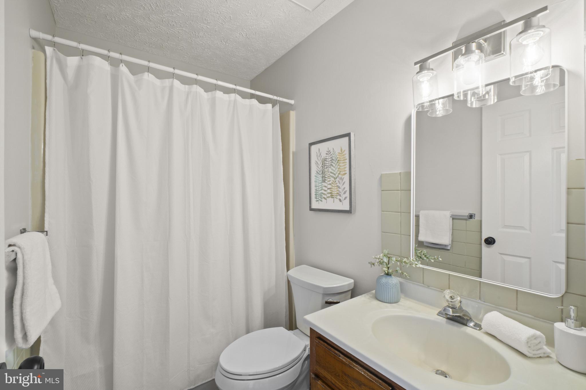 607 Brentwood Road Linthicum Heights, MD 21090 - Photo 20 of 31 a bathroom with a sink a toilet and shower curtain
