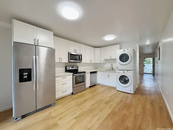 a kitchen with a refrigerator a stove top oven and cabinets