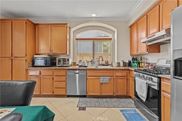 a kitchen with stainless steel appliances granite countertop a stove a sink and a refrigerator