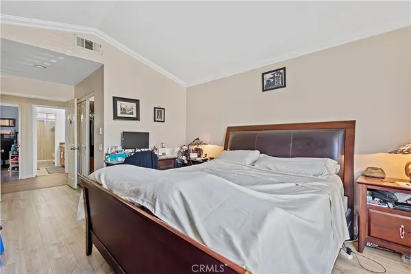 a bedroom with bed and wooden floor