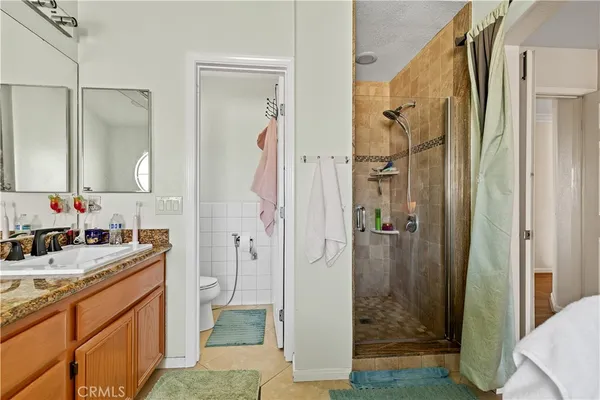 a bathroom with a granite countertop sink a mirror and a shower
