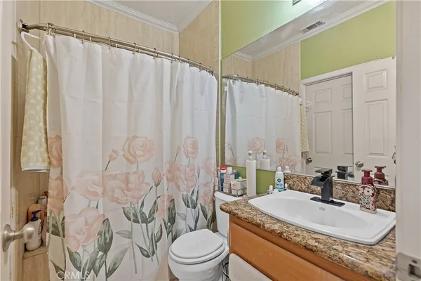a bathroom with a granite countertop sink a toilet and a mirror