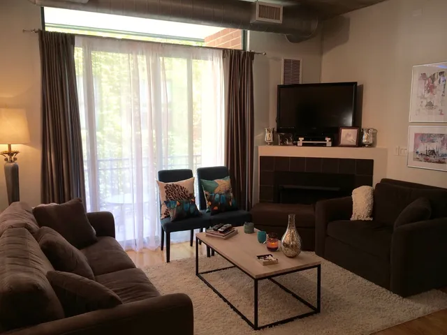 a living room with furniture a flat screen tv and a window
