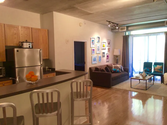 a living room with furniture and a refrigerator