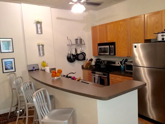 a kitchen with stainless steel appliances granite countertop a sink refrigerator and microwave