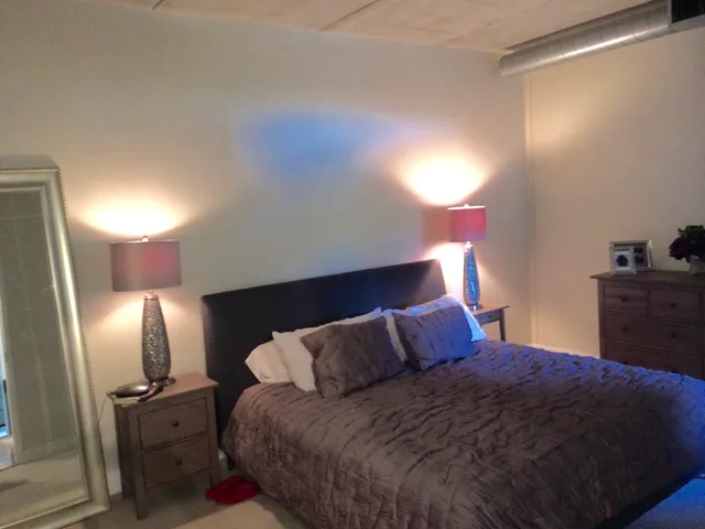 a bedroom with a bed and lamp on desk