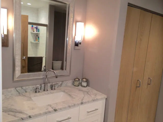 a bathroom with a granite countertop sink and a mirror