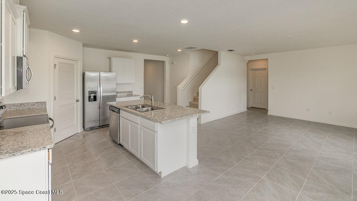 598 Ganley Street Palm Bay, FL 32908 - Photo 5 of 25 a kitchen with a sink stove and refrigerator