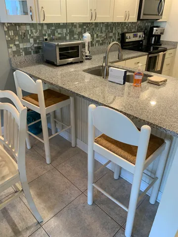 a kitchen with stainless steel appliances granite countertop a sink and a stove
