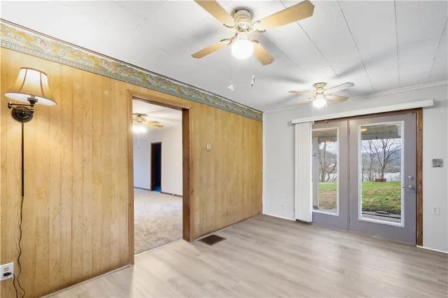 a view of a big room with a chandelier fan and windows