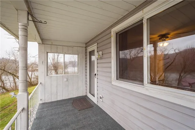 a view of a porch with a door and wooden floor