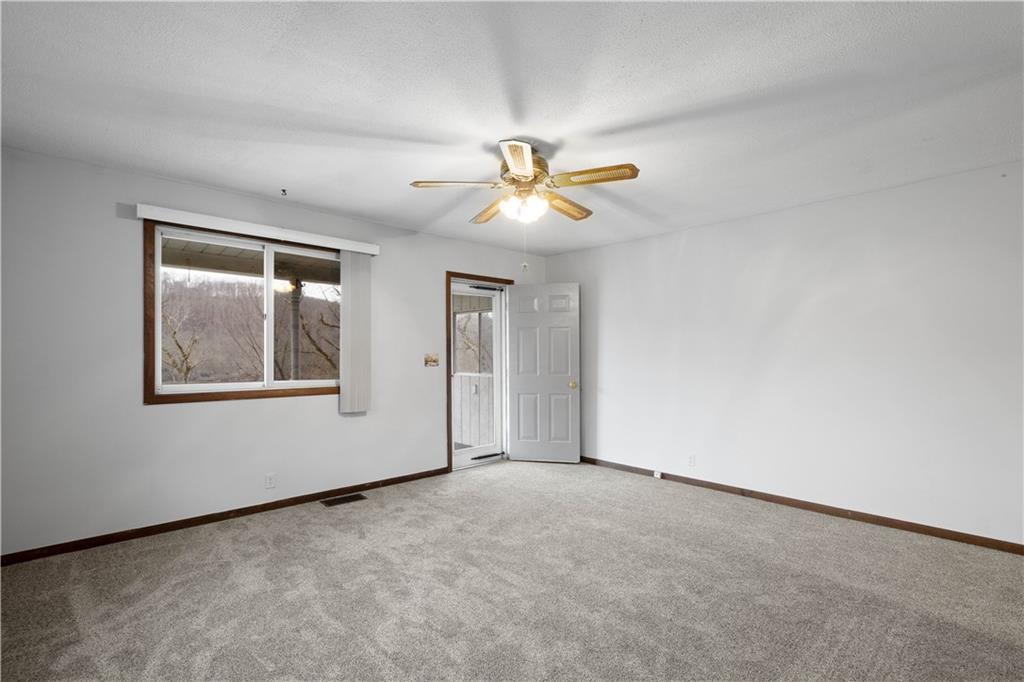 107 Center Street Millsboro, PA 15348 - Photo 7 of 34 an empty room with a window and a fan