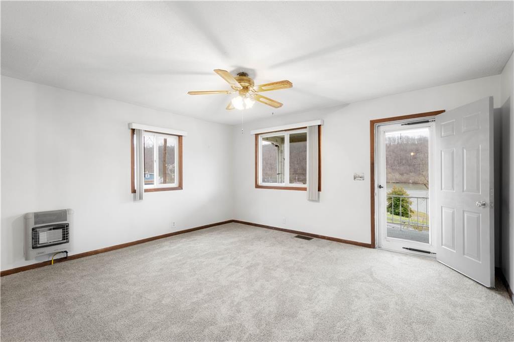 107 Center Street Millsboro, PA 15348 - Photo 8 of 34 an empty room with windows and chandelier fan