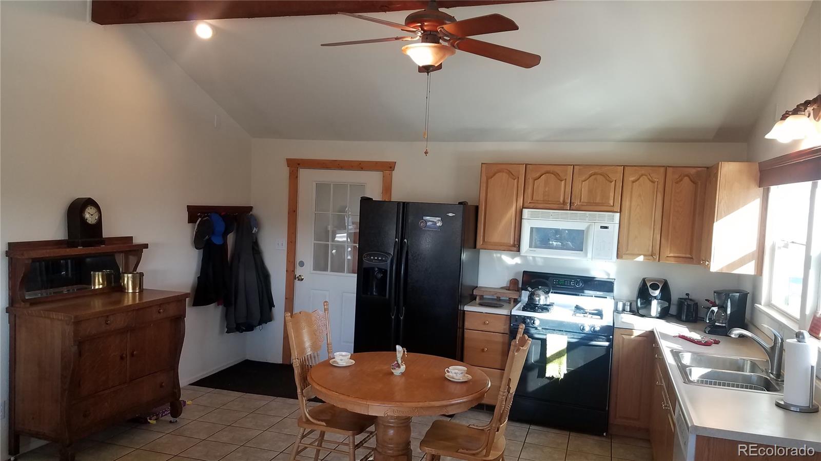 67 Hold Up Street Bailey, CO 80421 - Photo 17 of 25 a kitchen with stainless steel appliances kitchen island granite countertop a refrigerator a stove a sink a microwave oven with white cabinets and wooden floor