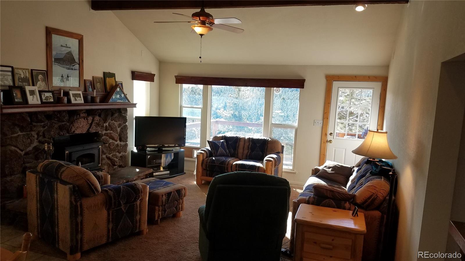 67 Hold Up Street Bailey, CO 80421 - Photo 18 of 25 a living room with furniture a fireplace and a flat screen tv