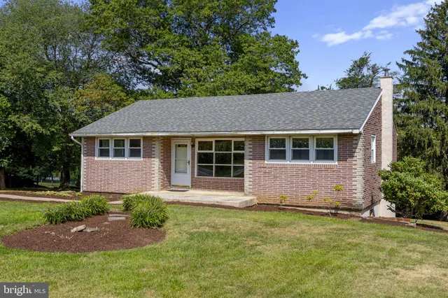 a front view of a house with a garden and yard