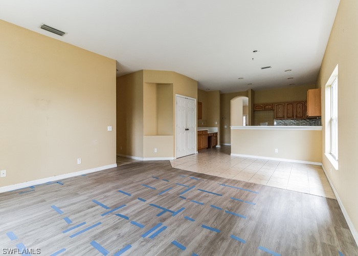8981 Falcon Pointe Loop Fort Myers, FL 33912 - Photo 14 of 25 a view of a big room with wooden floor and a kitchen