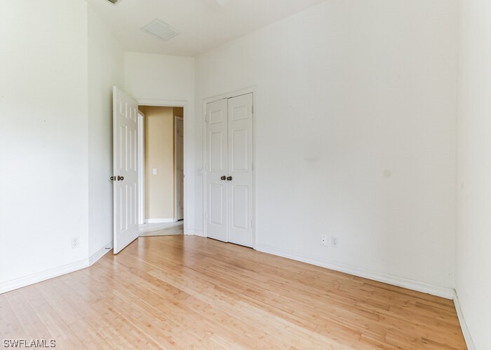 8981 Falcon Pointe Loop Fort Myers, FL 33912 - Photo 18 of 25 a view of an empty room with wooden floor