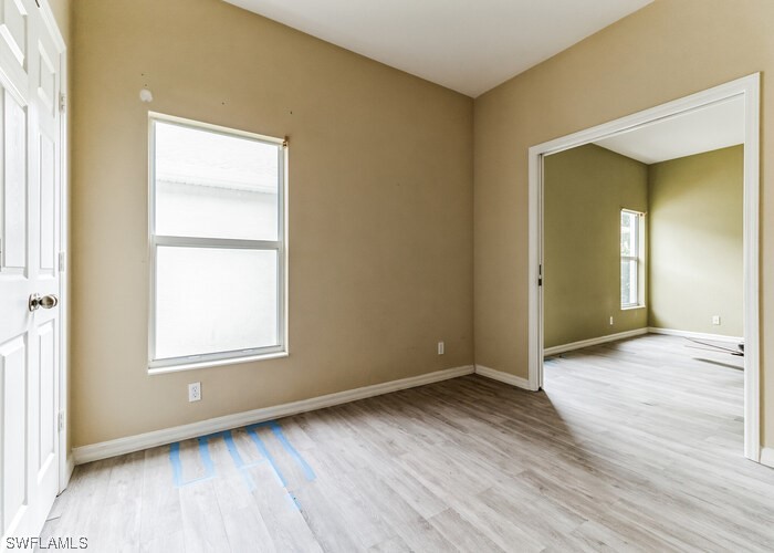 8981 Falcon Pointe Loop Fort Myers, FL 33912 - Photo 19 of 25 an empty room with wooden floor and windows