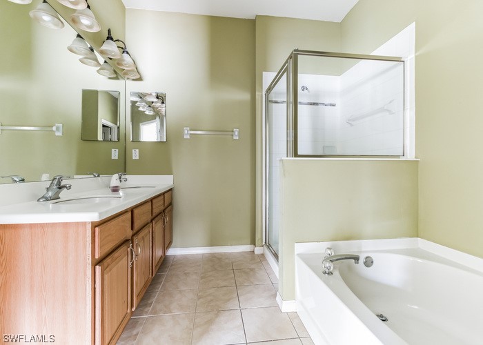 8981 Falcon Pointe Loop Fort Myers, FL 33912 - Photo 22 of 25 a bathroom with a tub a sink and mirror