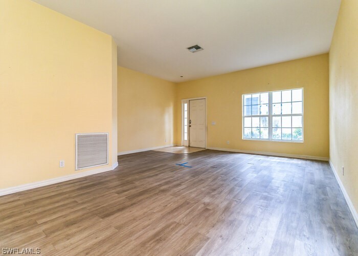 8981 Falcon Pointe Loop Fort Myers, FL 33912 - Photo 7 of 25 an empty room with wooden floor and windows