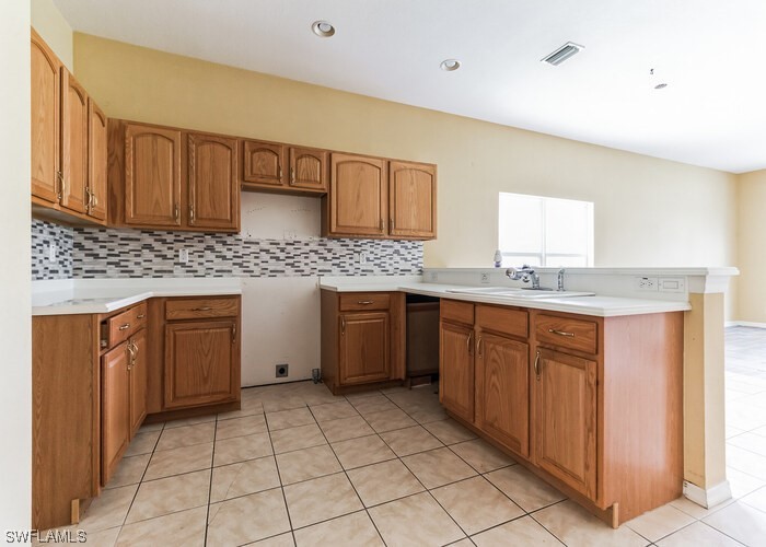 8981 Falcon Pointe Loop Fort Myers, FL 33912 - Photo 9 of 25 a kitchen with stainless steel appliances granite countertop a sink and cabinets