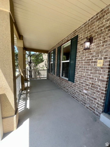 369 Culross Circle Tooele, UT 84074 - Photo 51 of 54 Covered front porch featuring a brick facade, decorative wall sconce, and dark green louvered shutters